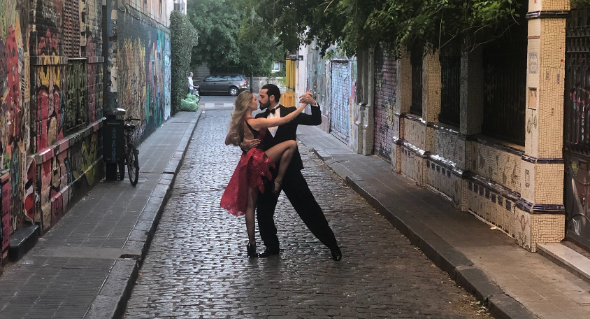 Picture of a man and woman dancing in the middle of an alleyway